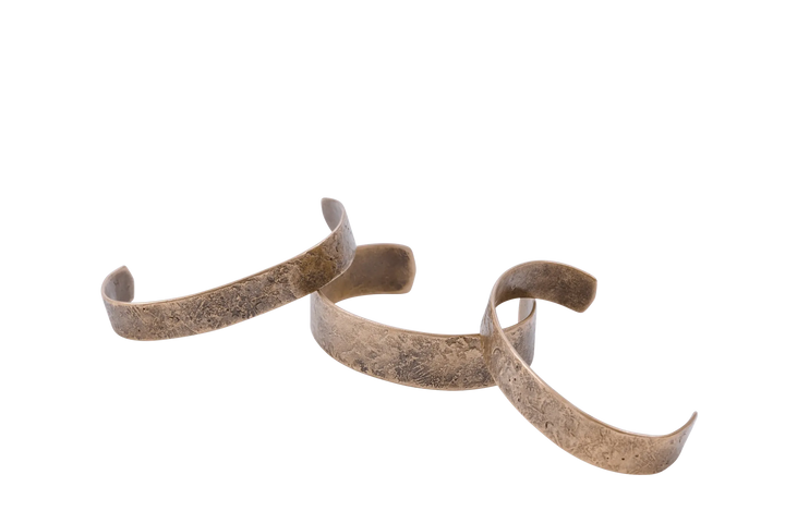 Dark Sky cuffs laid in a row showing the hammered surface texture