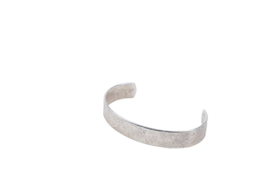 Sterling silver Dark Sky cuff shown open, side view, on a plain ground