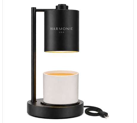 Harmonie matte black candle warmer lamp, flameless, with a white coconut wax candle on the base and a coiled black power cord, on a pure white background