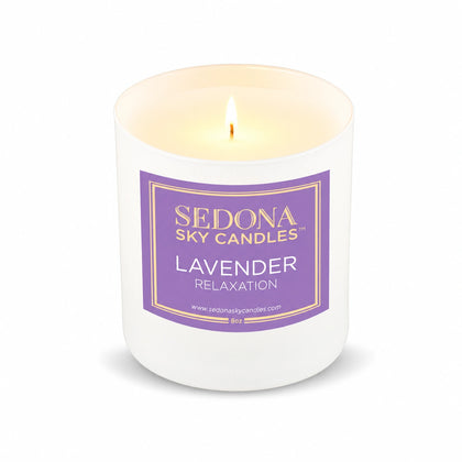 Lavender coconut wax candle, 8 oz, by Harmonie, lit with a glowing flame on a white background
