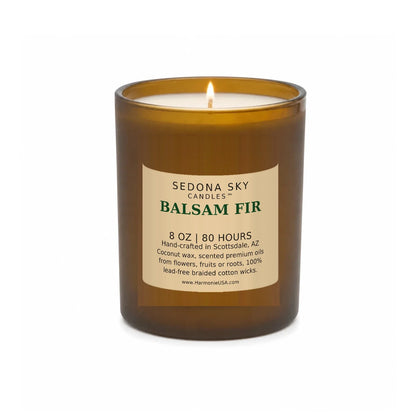 Sedona Sky Balsam Fir candle, 8 oz amber glass jar with matte Amber Sand label, lit wick and visible wax pool, on a seamless white background