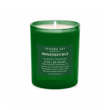 Sedona Sky Honeysuckle candle, 8 oz frosted emerald glass jar with matte matte emerald label, lit wick and visible wax pool, on a seamless white background