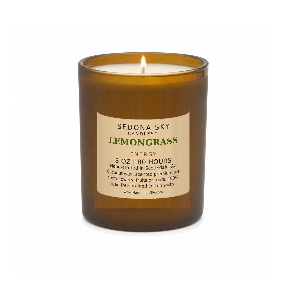 Sedona Sky Lemongrass Energy candle, 8 oz amber glass jar with matte Amber Sand label, lit wick and visible wax pool, on a seamless white background
