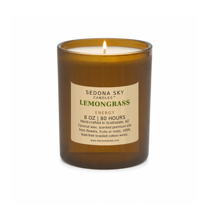 Sedona Sky Lemongrass Energy candle, 8 oz amber glass jar with matte Amber Sand label, lit wick and visible wax pool, on a seamless white background