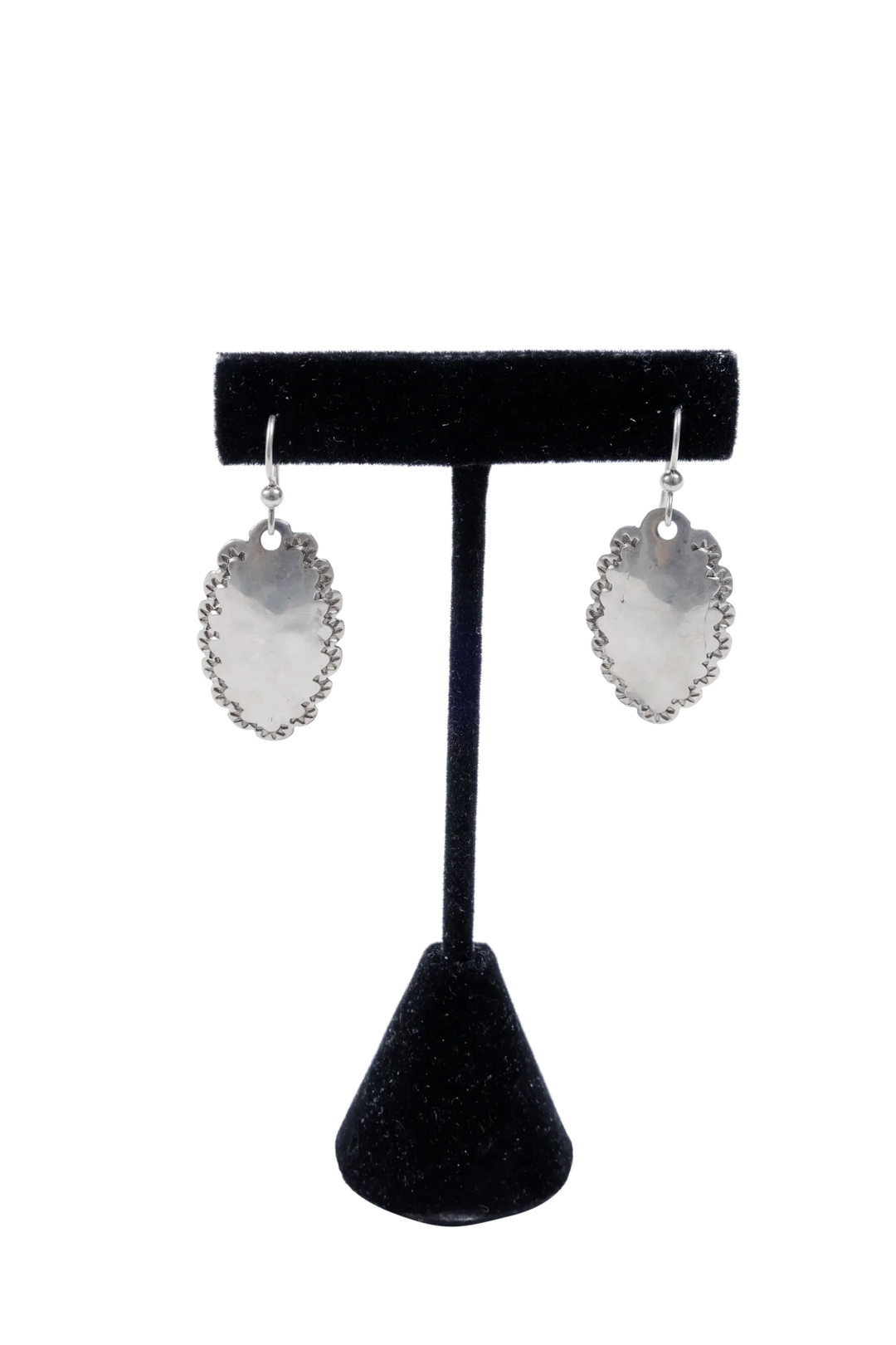 Single pair of hammered dime earrings on a display stand showing sterling posts and drop length