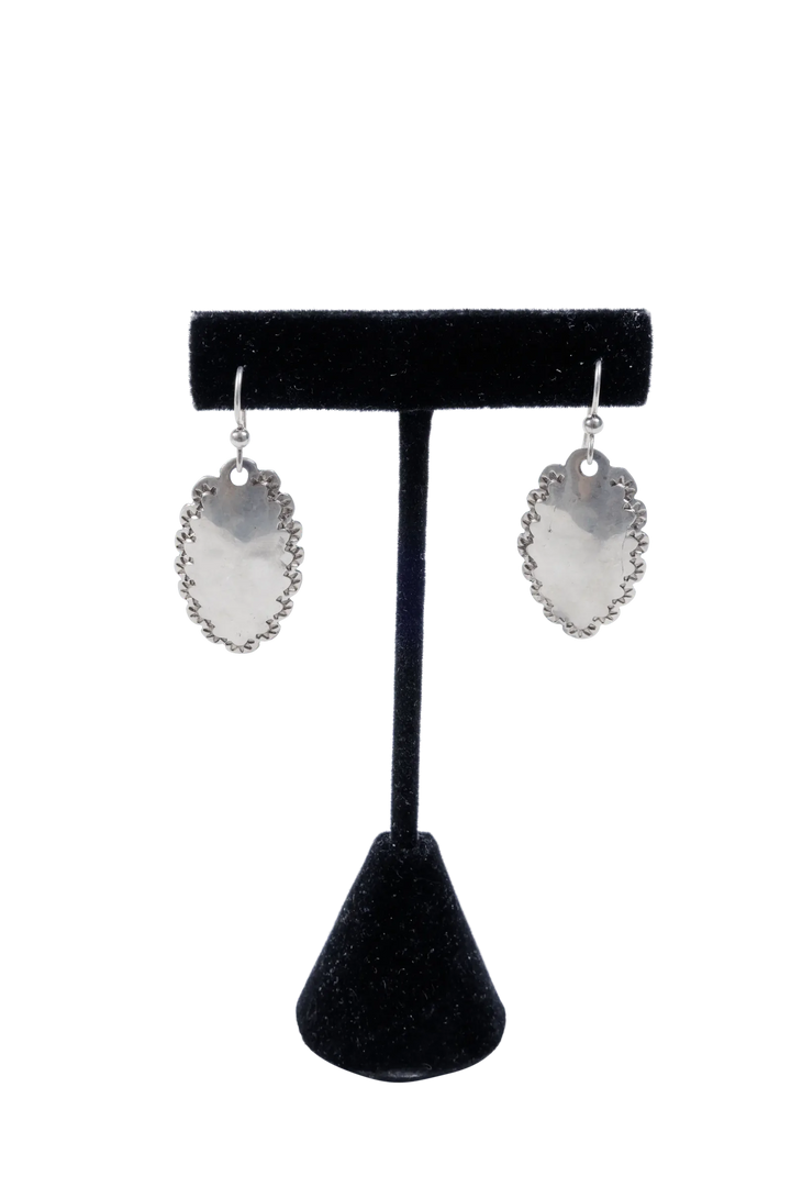 Single pair of hammered dime earrings on a display stand showing sterling posts and drop length